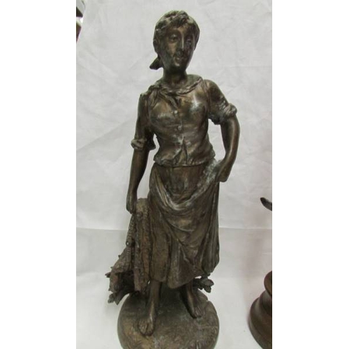 2053 - A spelter figure on a wooden base (34 cm) and another spelter figure (33cm).