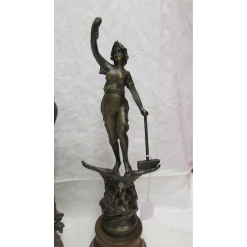 2053 - A spelter figure on a wooden base (34 cm) and another spelter figure (33cm).