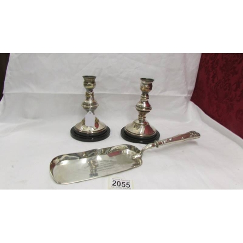 2055 - A pair of silver plate candlesticks and a silver plate fish slice.