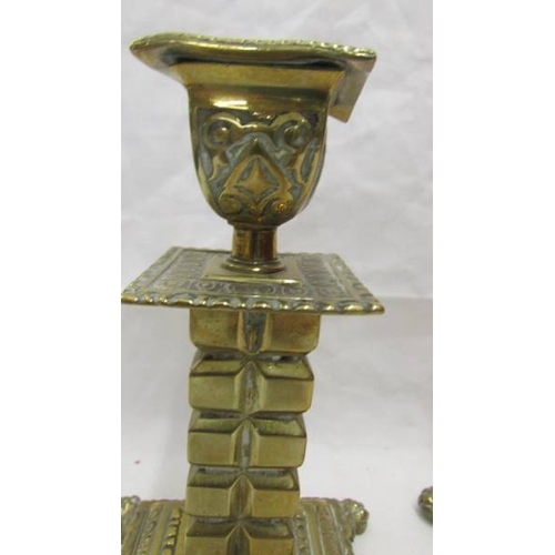 2057 - A pair of 19th century brass candlesticks on square footed bases with cubed columns.