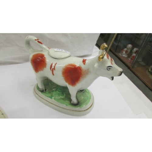 2257 - Two Staffordshire cow creamers (one a/f, missing top and damage to horn).