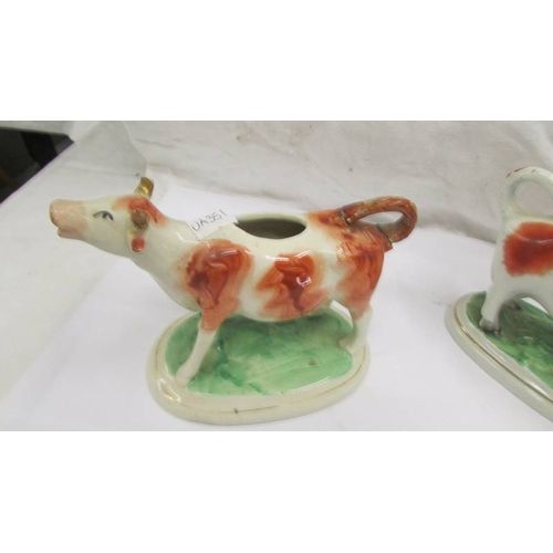 2257 - Two Staffordshire cow creamers (one a/f, missing top and damage to horn).