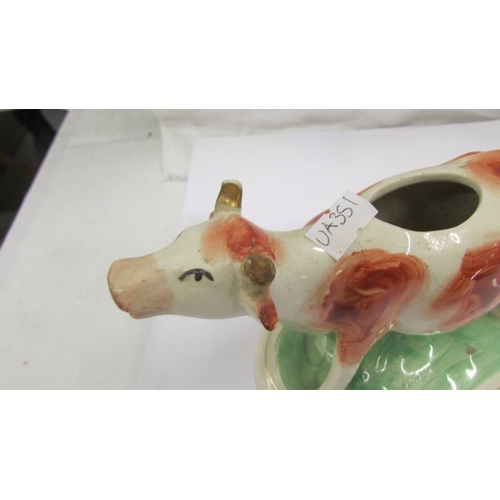 2257 - Two Staffordshire cow creamers (one a/f, missing top and damage to horn).