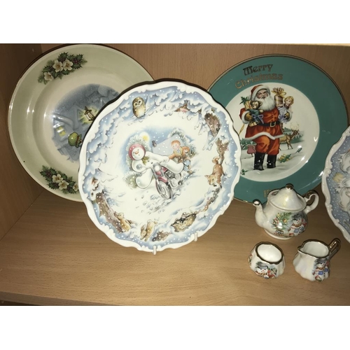 1249 - 6 Christmas plates, 2 snowmen money boxes & other Christmas items (2 shelves)