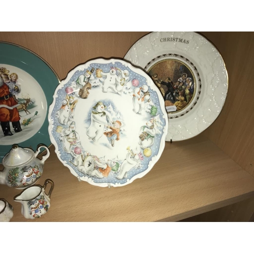 1249 - 6 Christmas plates, 2 snowmen money boxes & other Christmas items (2 shelves)