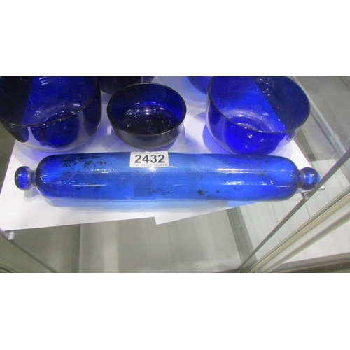 2432 - A Bristol blue glass rolling pin and seven blue glass bowls. (Collect only)