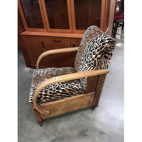 1560 - A 1930's oak framed armchair with later leopard print upholstery