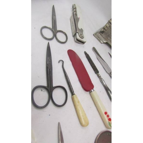 2121 - A mixed lot including metal cigarette box, a cut throat razor, a paperknife, various knives, scissor... 