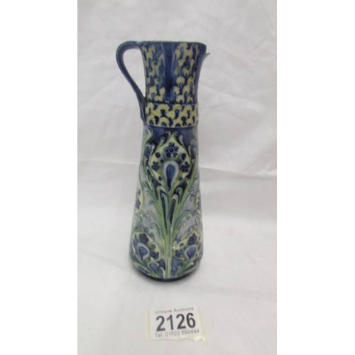 2126 - A Moorcroft Macintyre Florian ware jug, a/f damage to spout and crazing to glaze). 20cm tall.