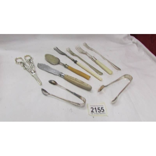 2155 - Four pickle forks, two sugar tongs, butter knife, spoon and grape scissors.