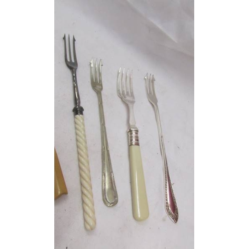 2155 - Four pickle forks, two sugar tongs, butter knife, spoon and grape scissors.