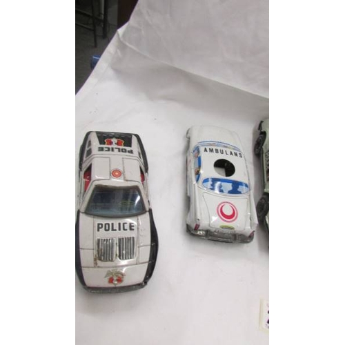 2464 - Three Japanese tin plate friction police cars, another police car and an ambulance.