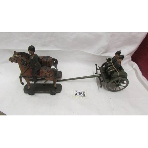 2466 - A pre-war tin plate military carriage with hard plastic figures and horses, no visible makers marks.