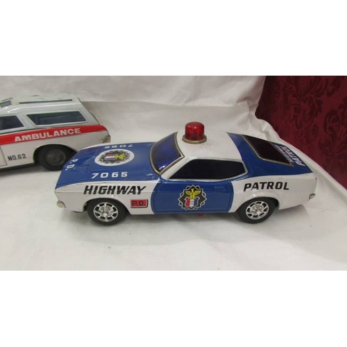 2469 - A large Japanese A1 HSAKUSA tinplate battery operated Buick ambulance and an un-named police Ford Mu... 