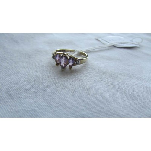 3 - A three stone 9ct gold diamond and amethyst ring, size O.