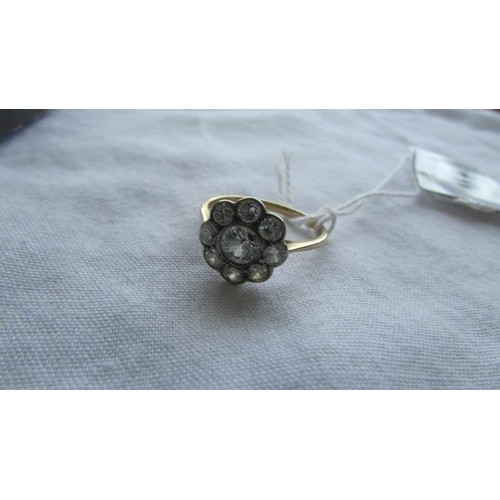 10 - An 18ct gold cluster ring with large central diamond surrounded by eight smaller diamonds, size 0 Ha... 