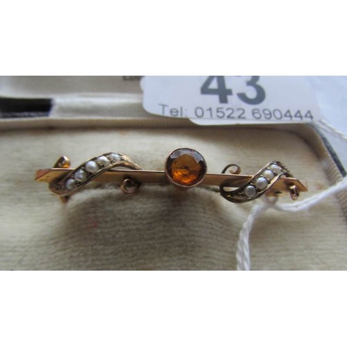 43 - A 9ct gold brooch set amber coloured stone and seed pearls.