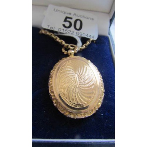 50 - A 15 ct gold locket. 10 grams, on a gold chain 8.8 grams.