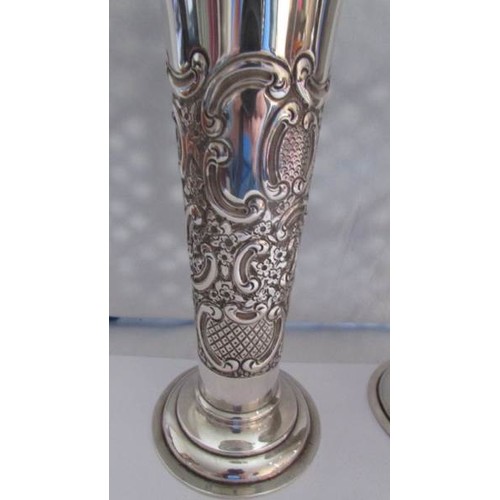 87 - A pair of silver embossed vases.