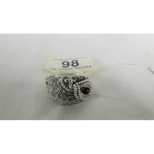 98 - A sterling silver saddle ring set zirconia stones, size V.