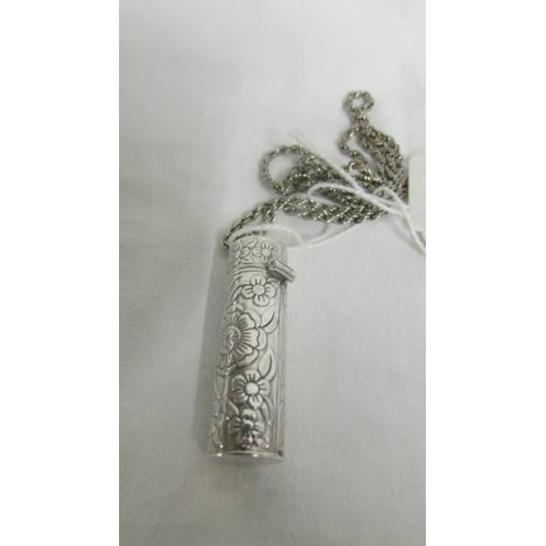 108 - A white metal locket on chain and a silver needlecase of white metal chain.