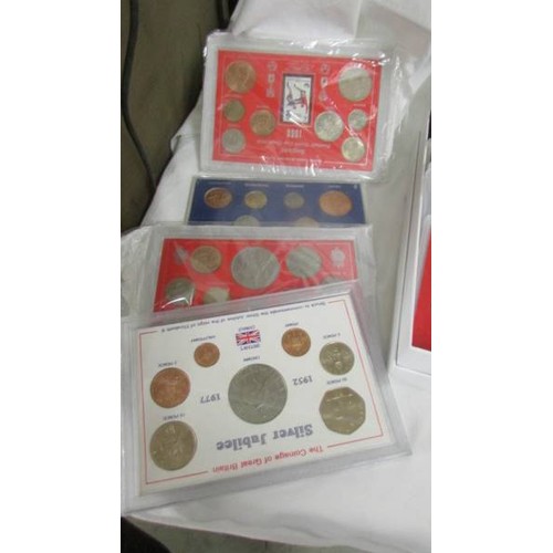 221 - A selection of UK coin sets including 1966 world cup, the coinage of George V, 1965 Churchill etc.,