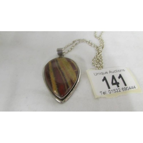 141 - A jasper stone pendant in a silver mount in a heart design on an attached silver chain.