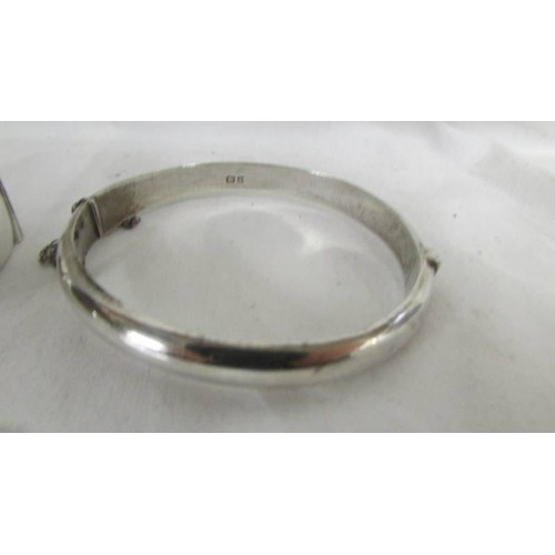 143 - A Chester 1957 silver bangle with chased work of flowers and foliage and a further silver bangle Bir... 