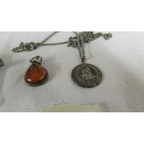 1007 - A silver St. Christopher on a white metal chain, a silver stone set cross pendant and a silver amber... 