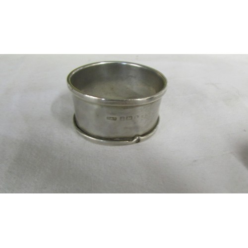 1009 - A silver pill box, a silver napkin ring and a silver bracelet.