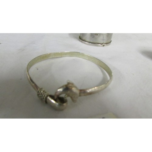 1009 - A silver pill box, a silver napkin ring and a silver bracelet.