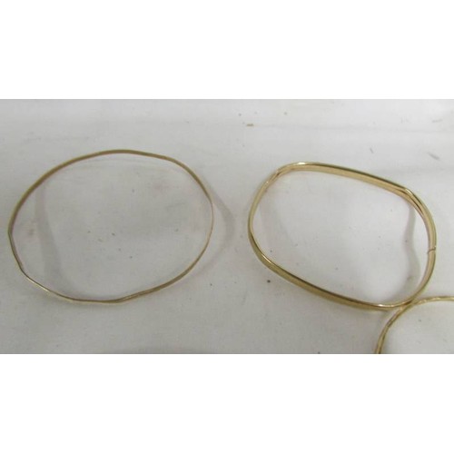 1018 - Four gold bangles and a gold locket. (17.2 grams).