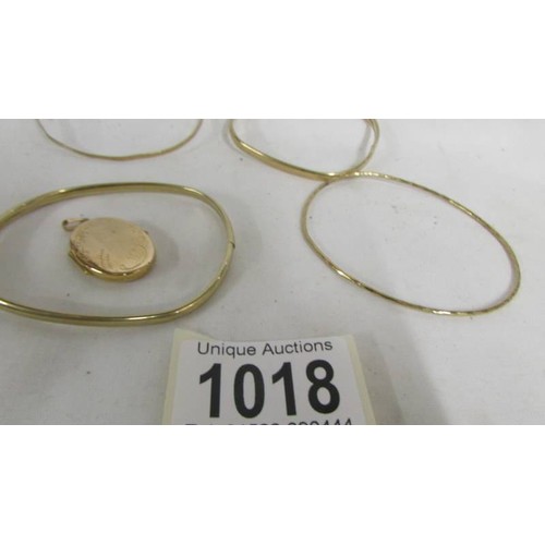 1018 - Four gold bangles and a gold locket. (17.2 grams).