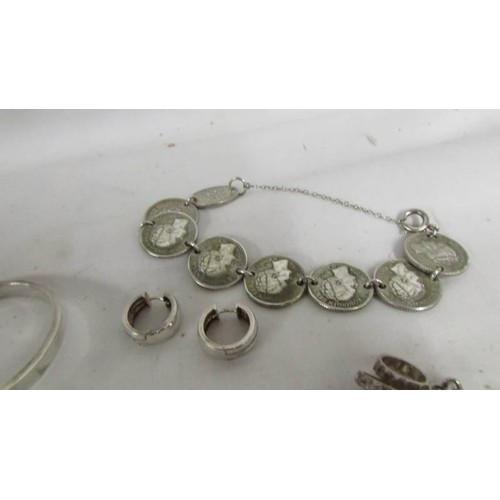 1019 - A silver charm bracelet, silver coin bracelet and other silver items.  (Approximately 65 g)