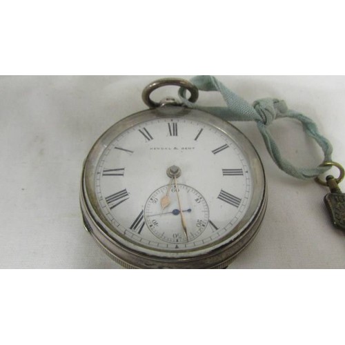 1025 - A Kendal and Dent silver pocket watch with key, in working order.