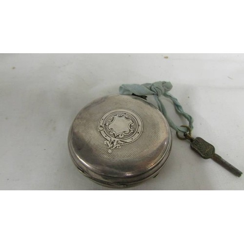 1025 - A Kendal and Dent silver pocket watch with key, in working order.