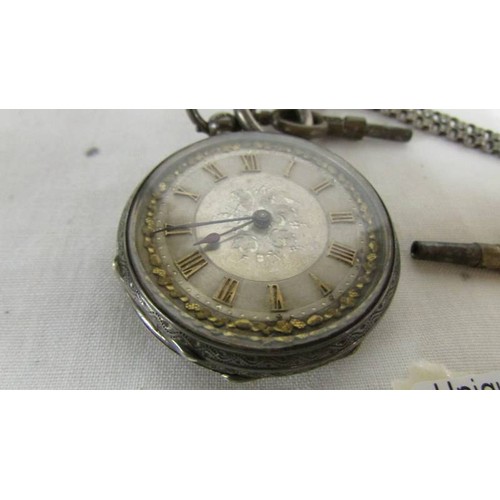 1031 - A Victorian ladies silver fob watch with ornate white metal chain.