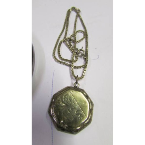 1049 - A silver locket on silver chain, a silver bangle and a silver brooch,