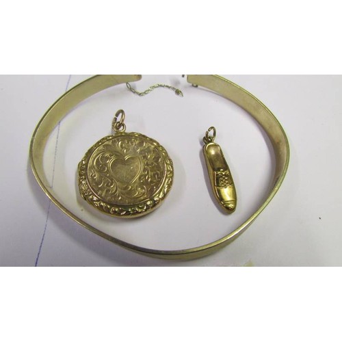 1057 - A 9ct gold locket, a 9ct gold bangle and a 9ct gold shoe charm, 16.3 grams.