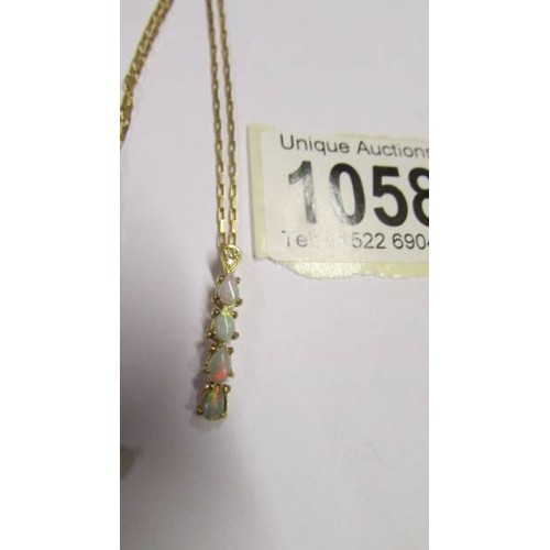 1058 - A 9ct gold pendant set opals on a 9ct gold chain, 2.6 grams.