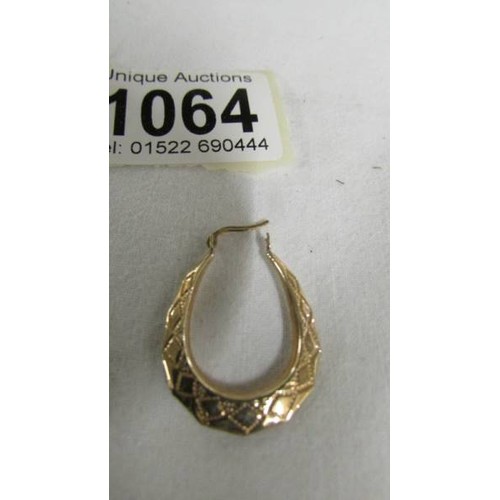 1064 - A pair of 9ct gold textured hoop earrings.