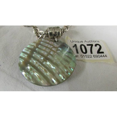 1072 - A silver chain with attached mother of pearl pendant, total weight 61 grams.