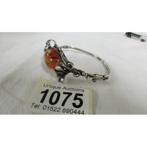 1075 - An oval amber and silver fancy work bracelet.