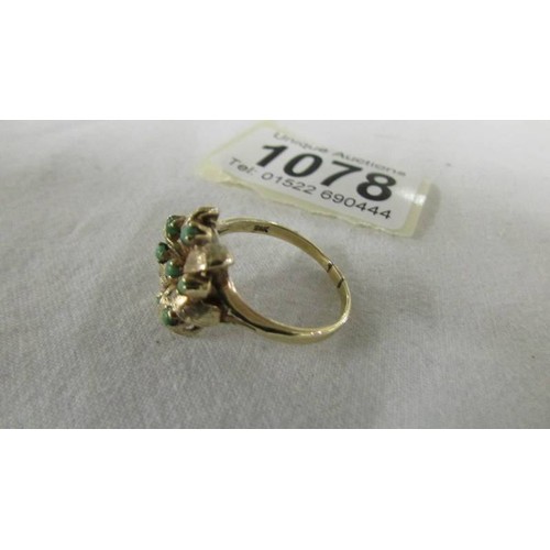 1078 - A textured gold ring dated 1967 set hardstones in flower design.