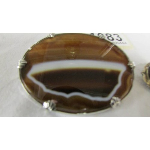 1083 - Two Victorian banded agate brooches, one in yellow metal, one in white metal.