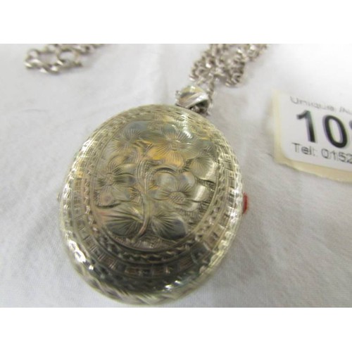 1085 - A silver engraved locket on a silver chain.