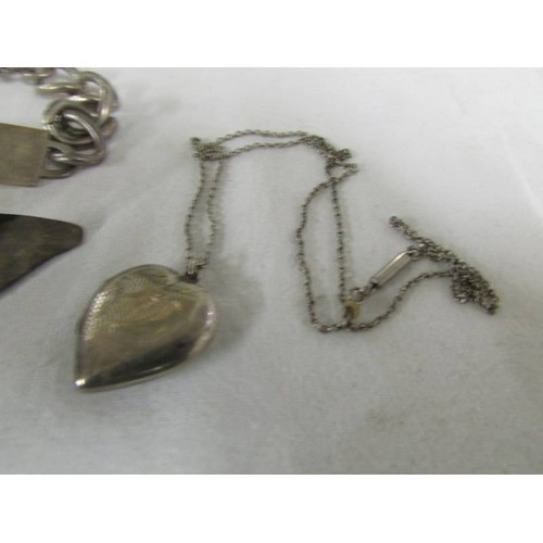 1086 - A silver identity bracelet, a silver brooch, a silver cross and a silver l0cket on chain.