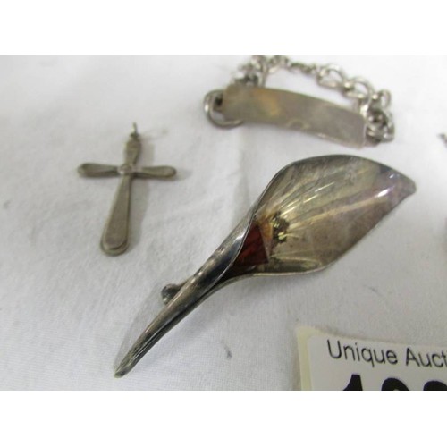 1086 - A silver identity bracelet, a silver brooch, a silver cross and a silver l0cket on chain.