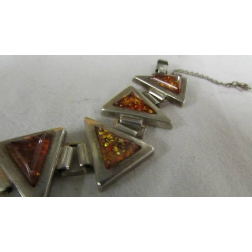 1017 - A triangular silver and amber bracelet.