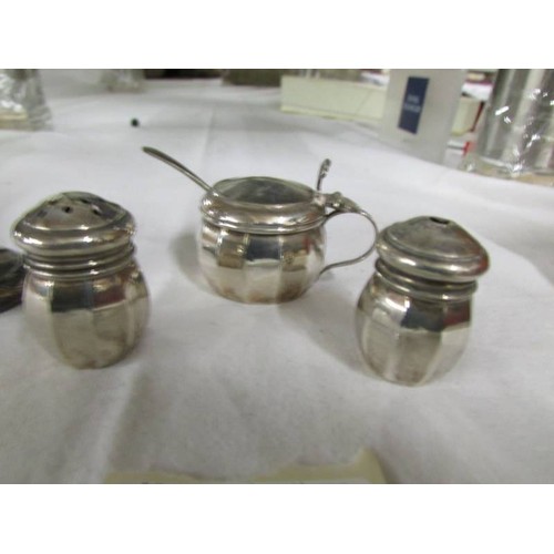 1112 - A silver three piece condiment set and a silver pepperette.